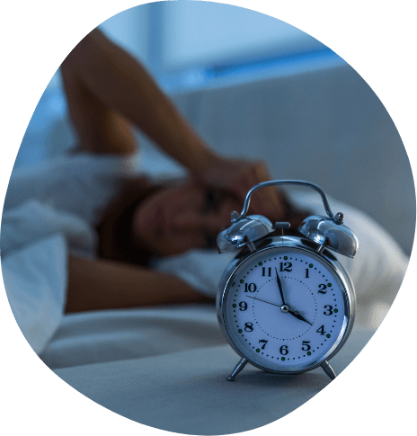 Sleeping person next to alarm clock showing the time as almost 4 A M