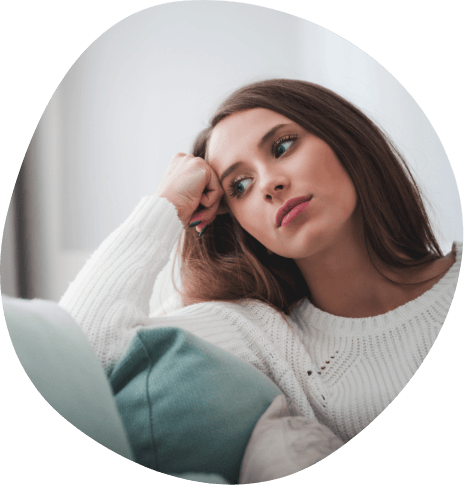 Woman in white sweater sitting on couch