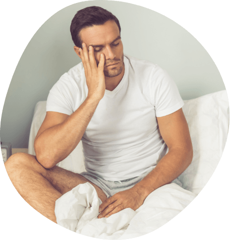 Tired man sitting up in bed