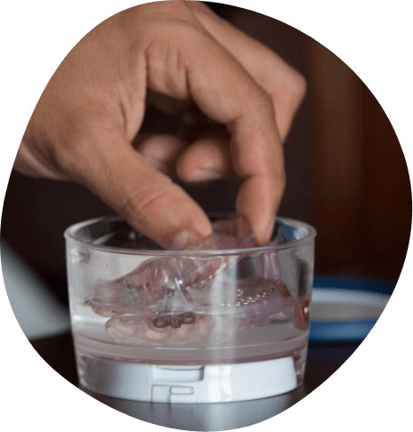 Person placing oral appliance into glass of water