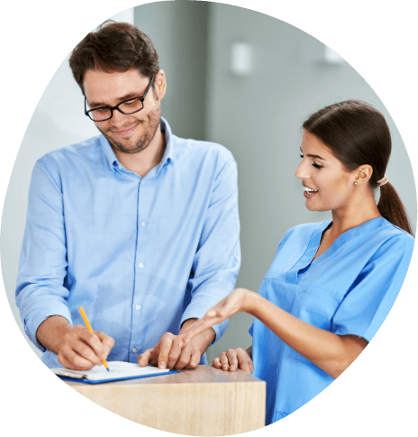 Sleep center team member showing patient where to sign on clipboard