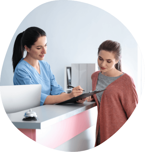 Sleep center team member showing patient where to sign on clipboard