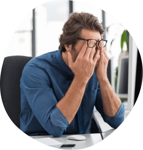 Man sitting at desk rubbing his eyes