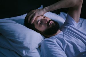 Man in bed unable to sleep