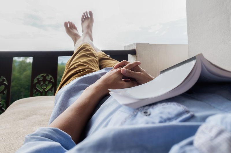 person lounging outside and reading a book